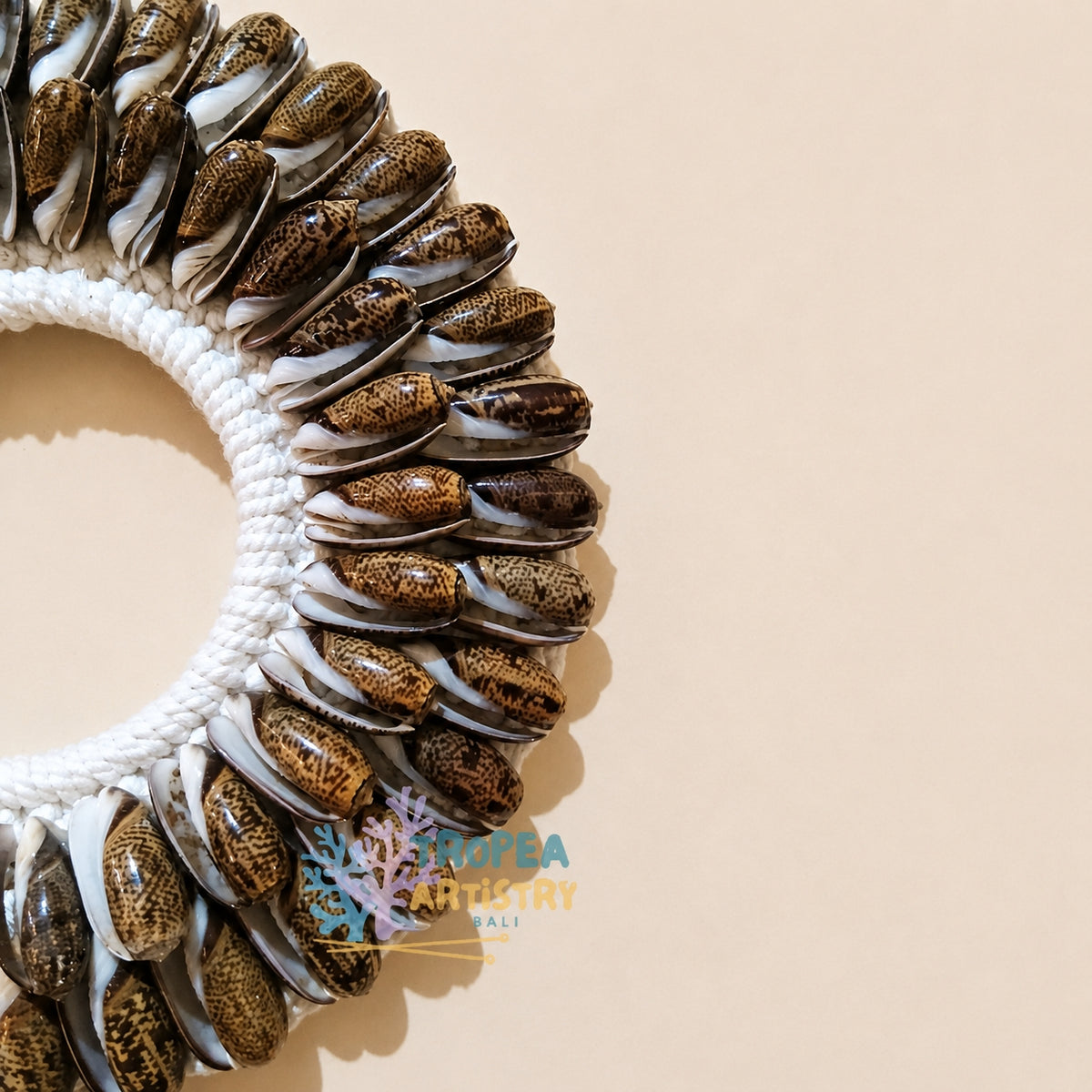 A circular wall hanging or decorative wreath made from many small brown and cream seashell-like pieces attached to a white rope ring, photographed on a plain warm beige background. A watermark reading "KOREA ANIMACY" appears near the bottom center.