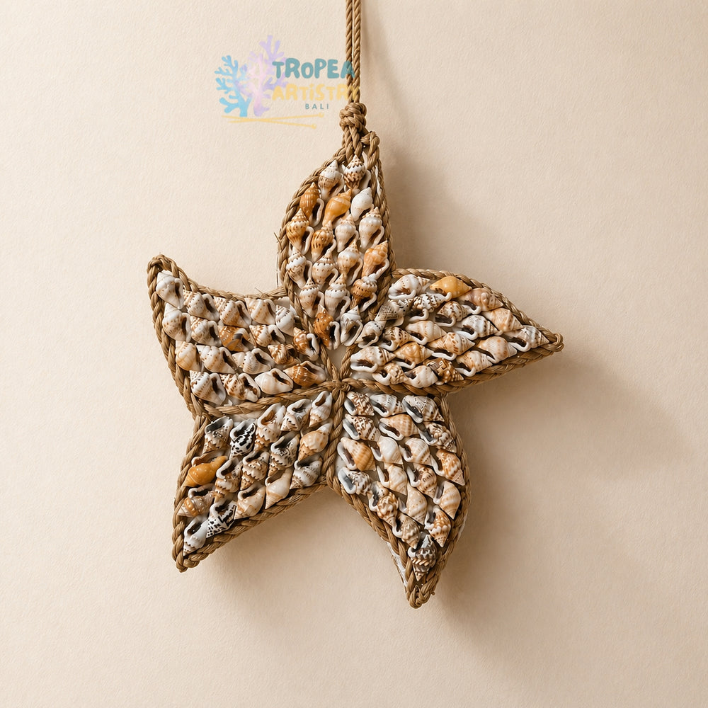 A starfish-shaped hanging ornament made from woven natural fiber and filled with small seashells, suspended against a plain beige background. A Tropea Artisan Sea logo is visible near the top center.